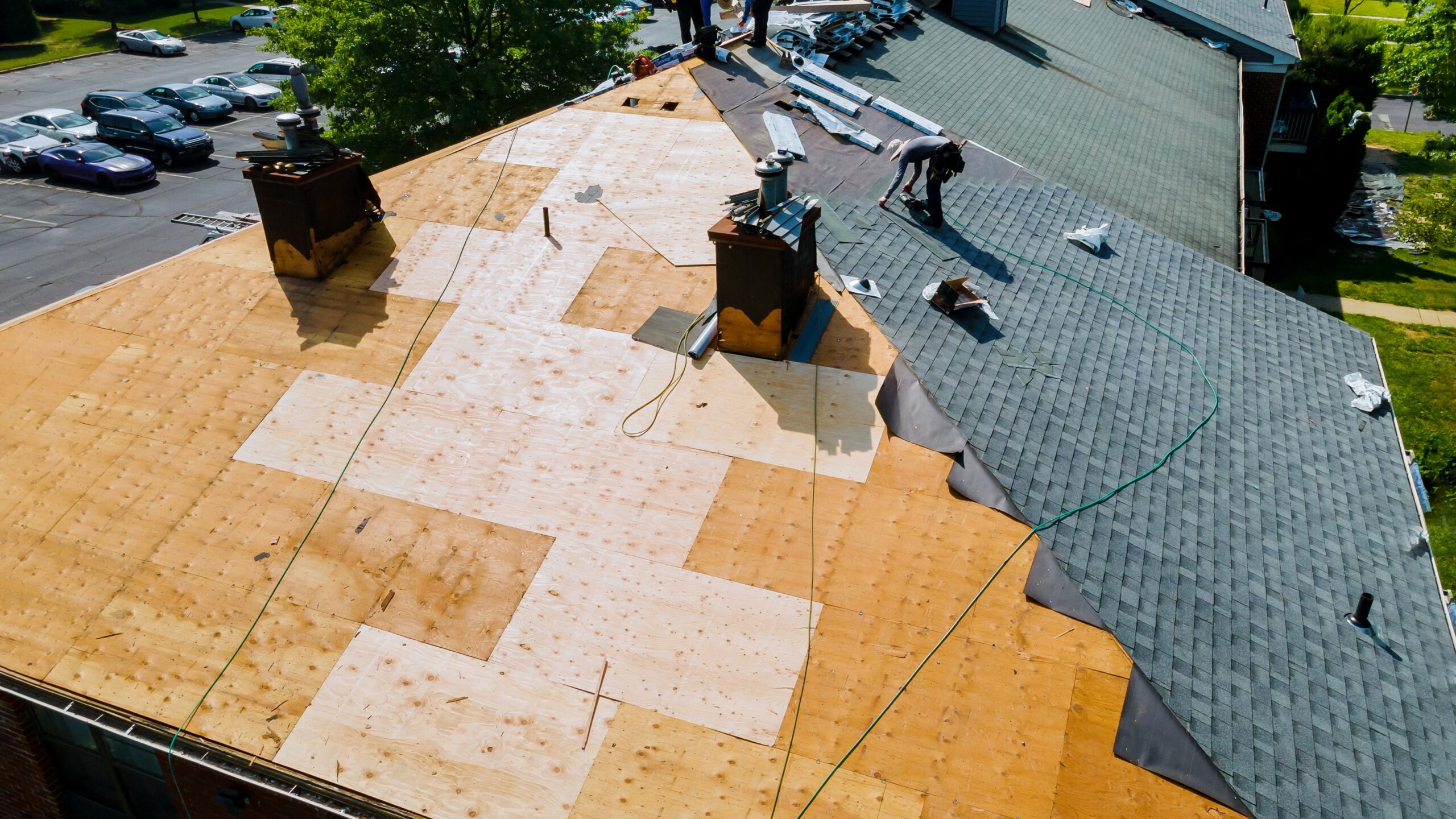 roofer installing shingles over roof decking