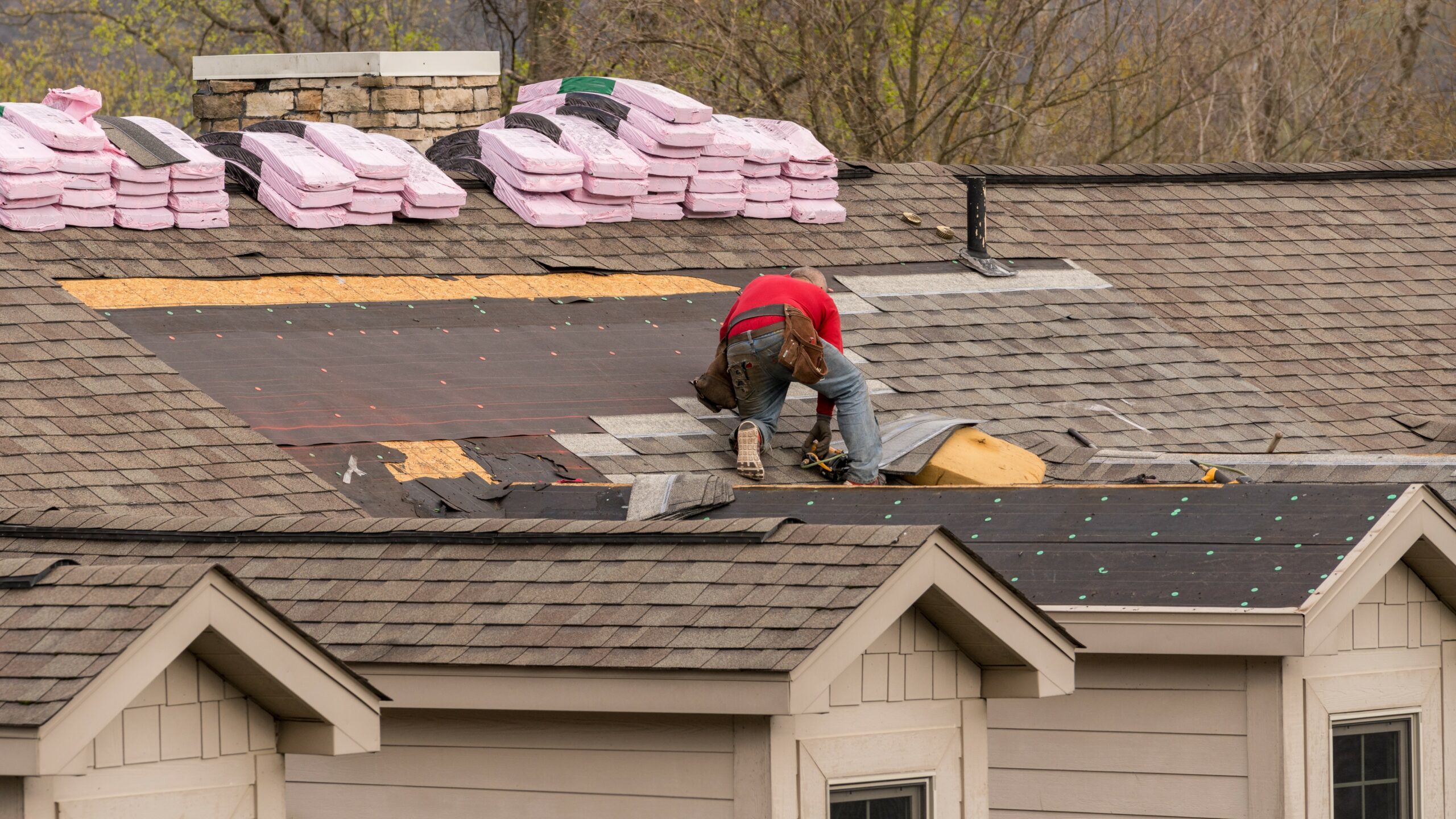 Roofer replacing area of shingles.